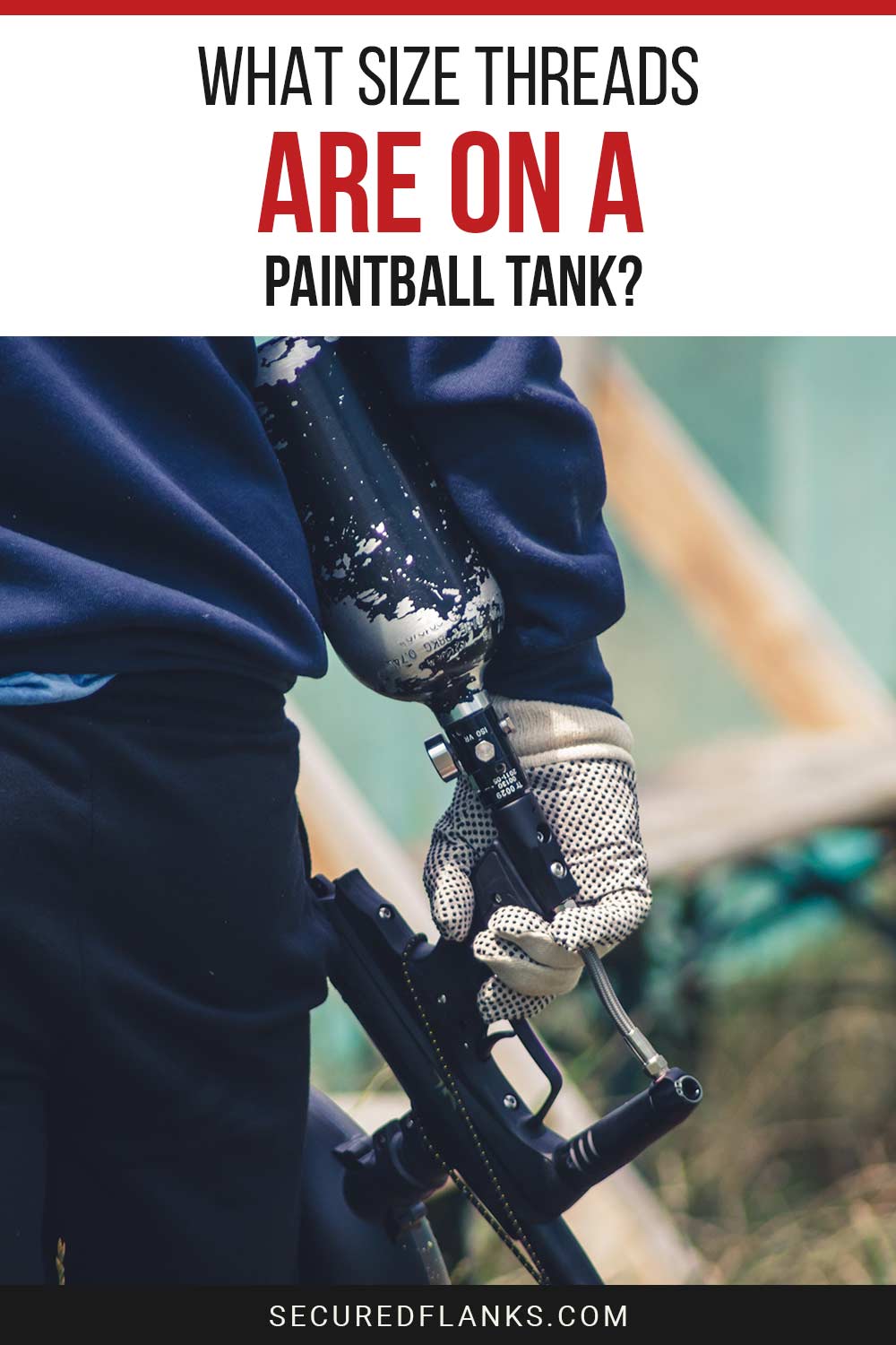 A paintball gun with a tank attached to it in a person's hand - What Size Threads Are On a Paintball Tank?