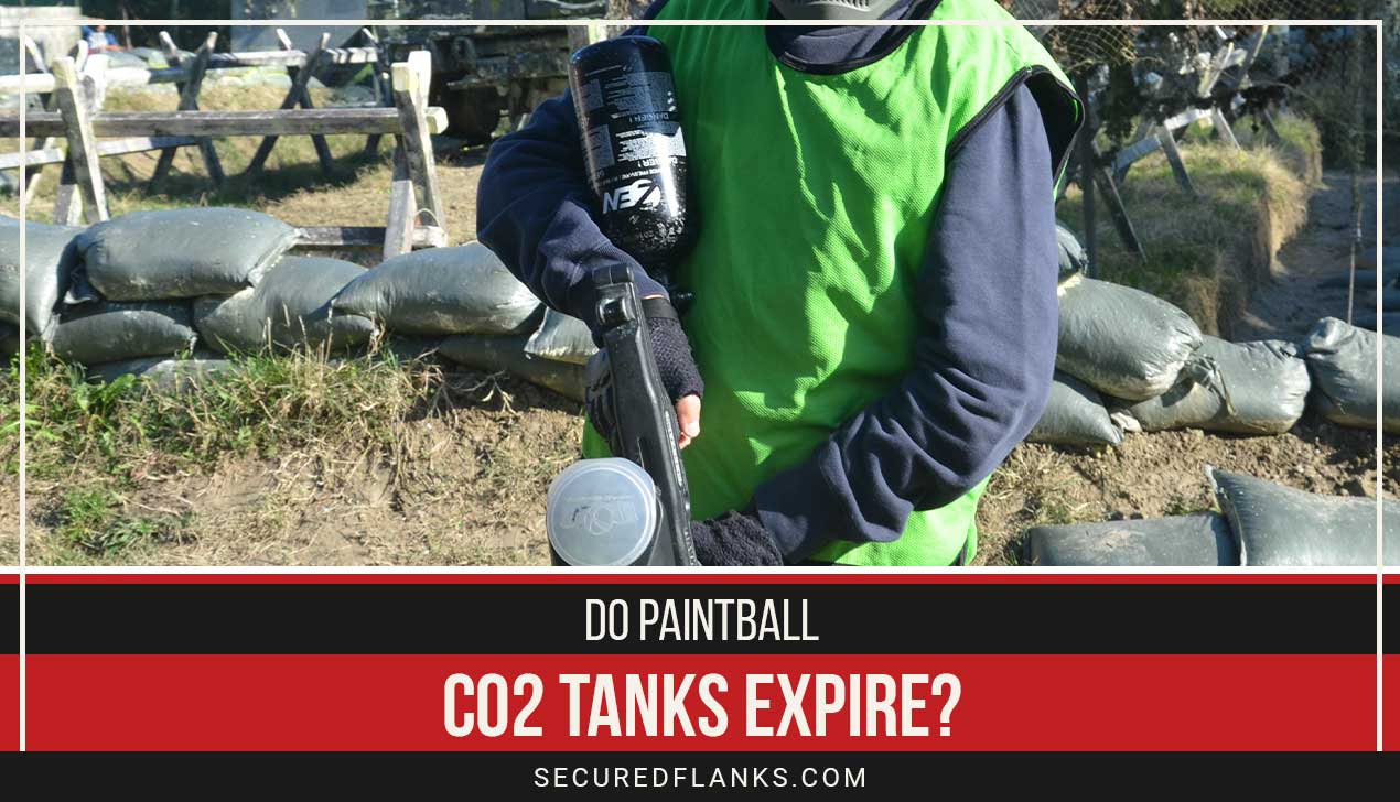 Man wearing green holding a paintball gun in hands - Do Paintball CO2 Tanks Expire?
