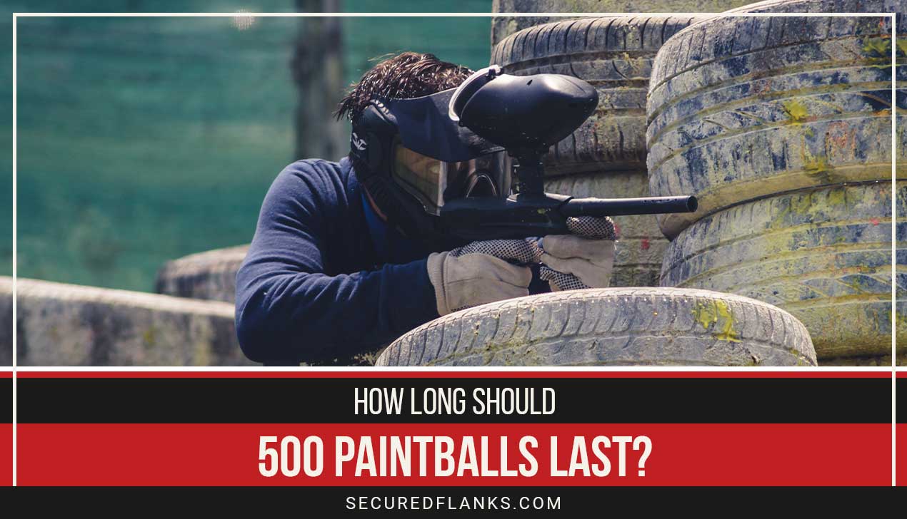 Person aiming leaning on tires - How Long Should 500 Paintballs Last?